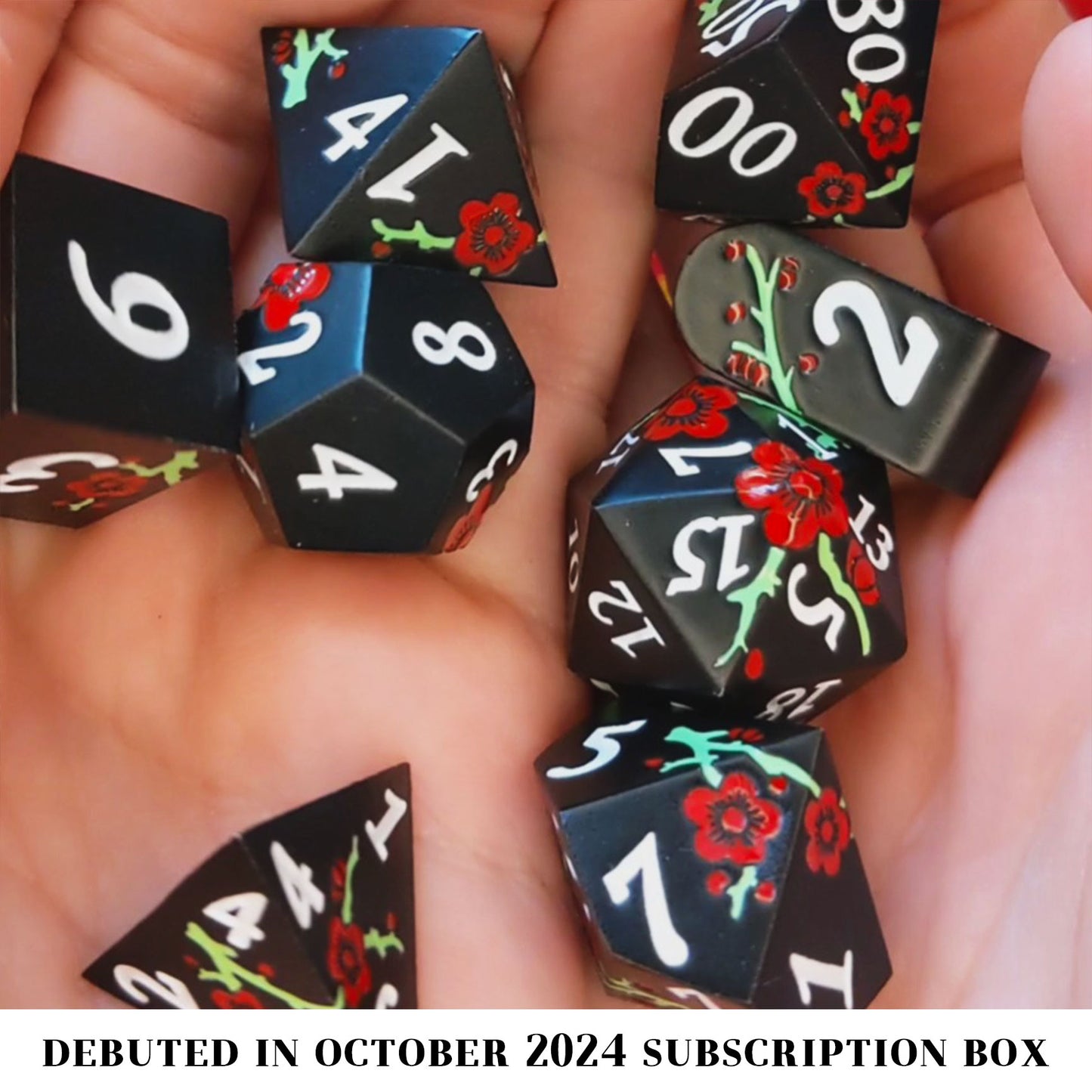 Hanahaki is an 8-piece set of satin black metal dice featuring red flowers, green branches, and white numbering.