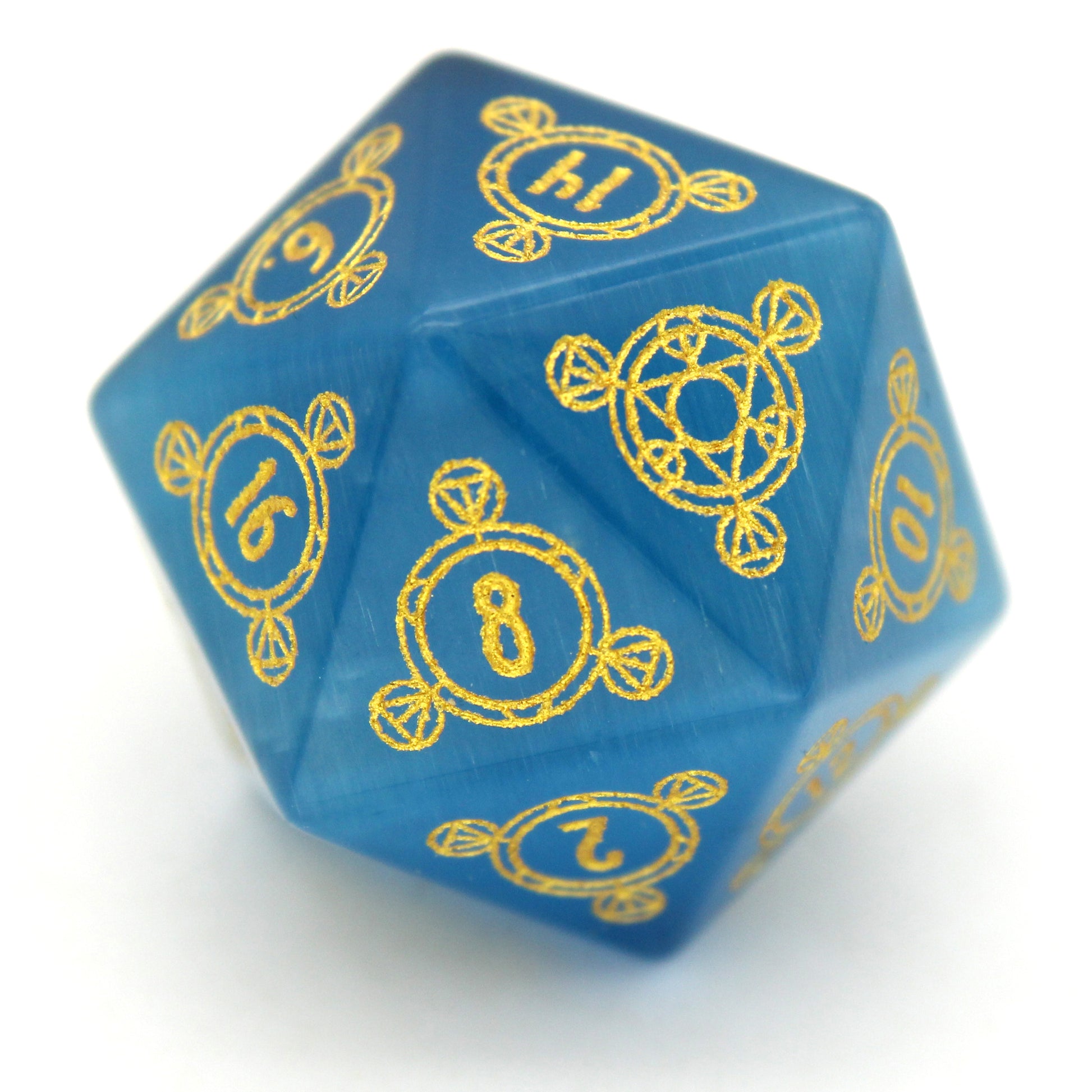 Midsummer's Eve is a 7-piece set of dice cut from blue, lab-made chatoyant stone, engraved with Dice Envy's exclusive Sigil design and inked in gold.