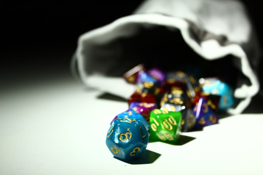 A gray bag with colorful dice spilling out.