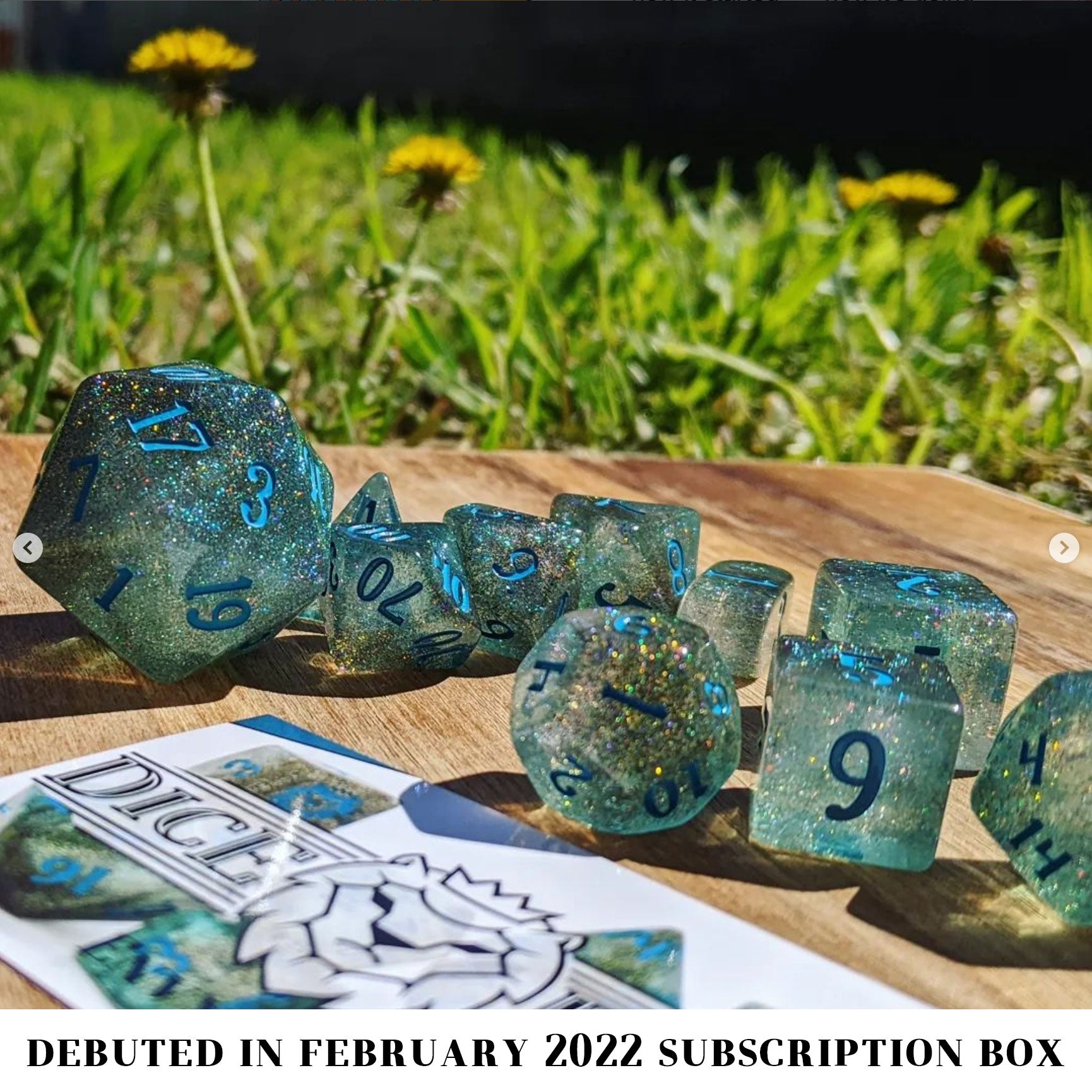 River Magic is a 10-piece dice set of swirling blue, brown, and clear resin, shot through with silver glitter and inked in teal.