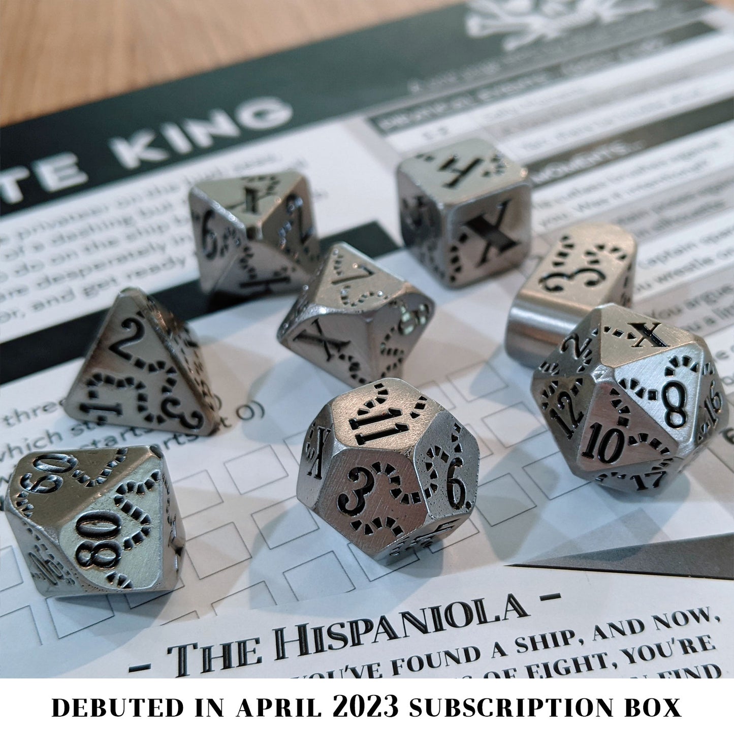 Hispaniola is a Dice Envy Exclusive 8-piece set of silver metal dice with a treasure map engraving inked in black. It is part of the Pirate Dice collection.