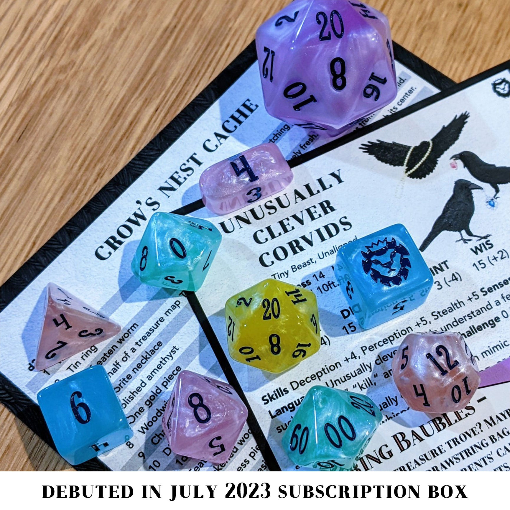 Shimmering Baubles is a 10-piece set of dice in shades of pastel rainbow, inked in dark blue.