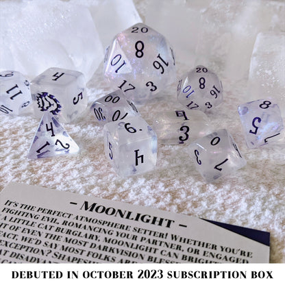 Moonlight is a 10-piece set of clear acrylic dice, filled with purple-blue colorshifting microglitter and inked in dark purple.