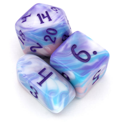 Accursed Confections is a 10-piece set of swirled acrylic dice in sugary blue, pink, purple, and white with dark purple ink.
