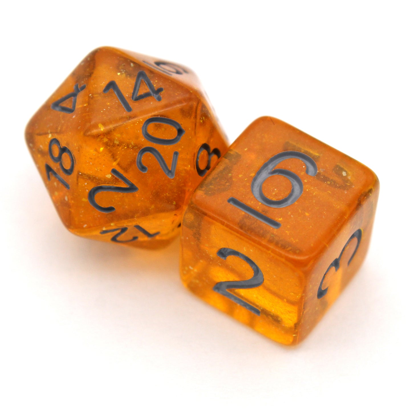 Bits-O-Honey is a 7-piece, 13mm polymer set of transparent amber resin dice, shimmering with silvery glitter and inked in dark grey. It belongs to our tiny but mighty Wee Lads collection. Standard d20 pictured for scale.