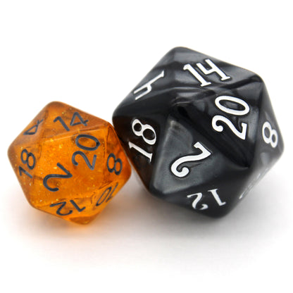 Bits-O-Honey is a 7-piece, 13mm polymer set of transparent amber resin dice, shimmering with silvery glitter and inked in dark grey. It belongs to our tiny but mighty Wee Lads collection. Standard d20 pictured for scale.