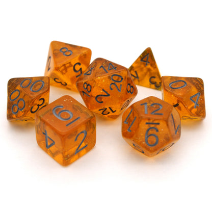 Bits-O-Honey is a 7-piece, 13mm polymer set of transparent amber resin dice, shimmering with silvery glitter and inked in dark grey. It belongs to our tiny but mighty Wee Lads collection. Standard d20 pictured for scale.