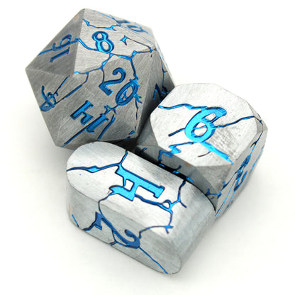 Cania Corrosion is an 8-piece set of silver dice, cracking to show depths and numbers of a shimmering metallic blue.