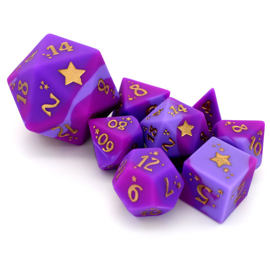 Chaotic Good is an 8-piece, swirled silicone dice set in noble pinks and purples. It features a starry-eyed, gold ink design.