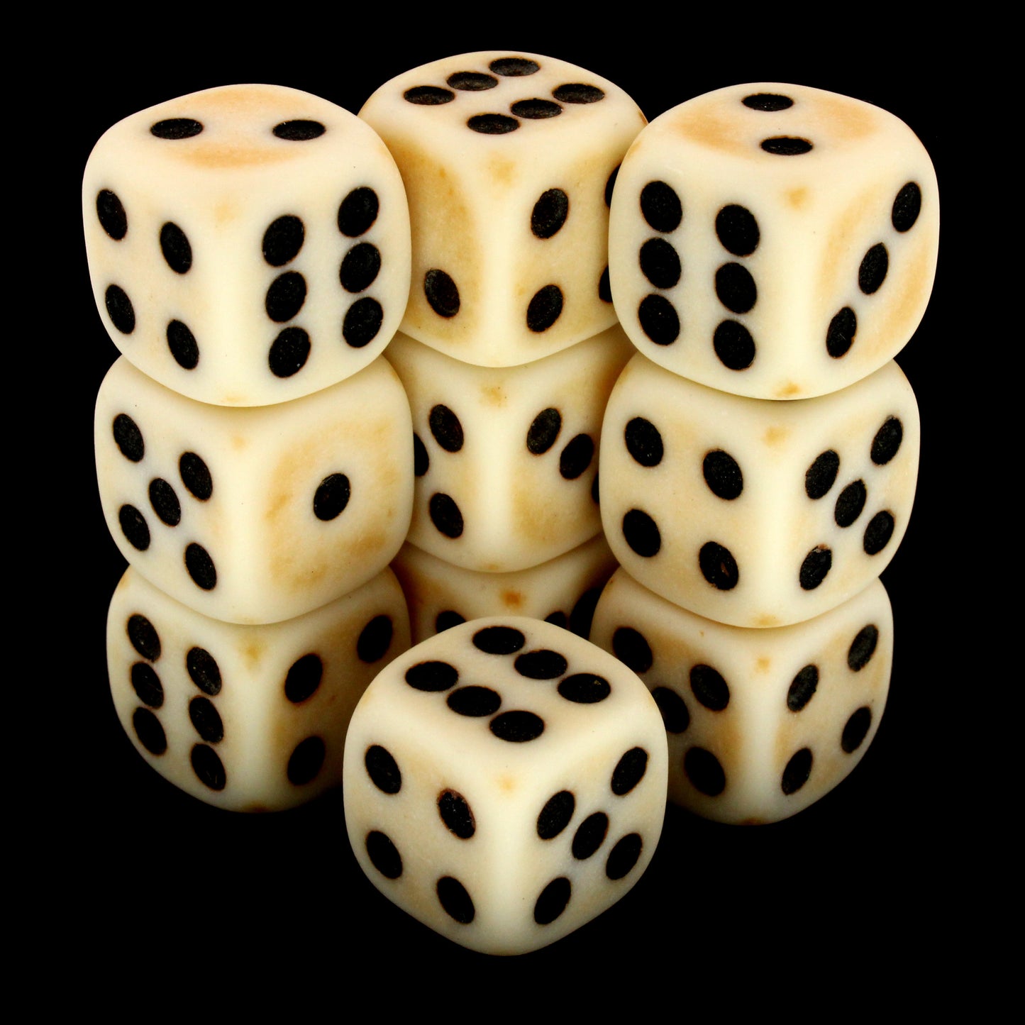 Crag Cat Claw is a 10-piece set of matte pale-colored 12mm d6s, with a natural patina, and pips inked in black.