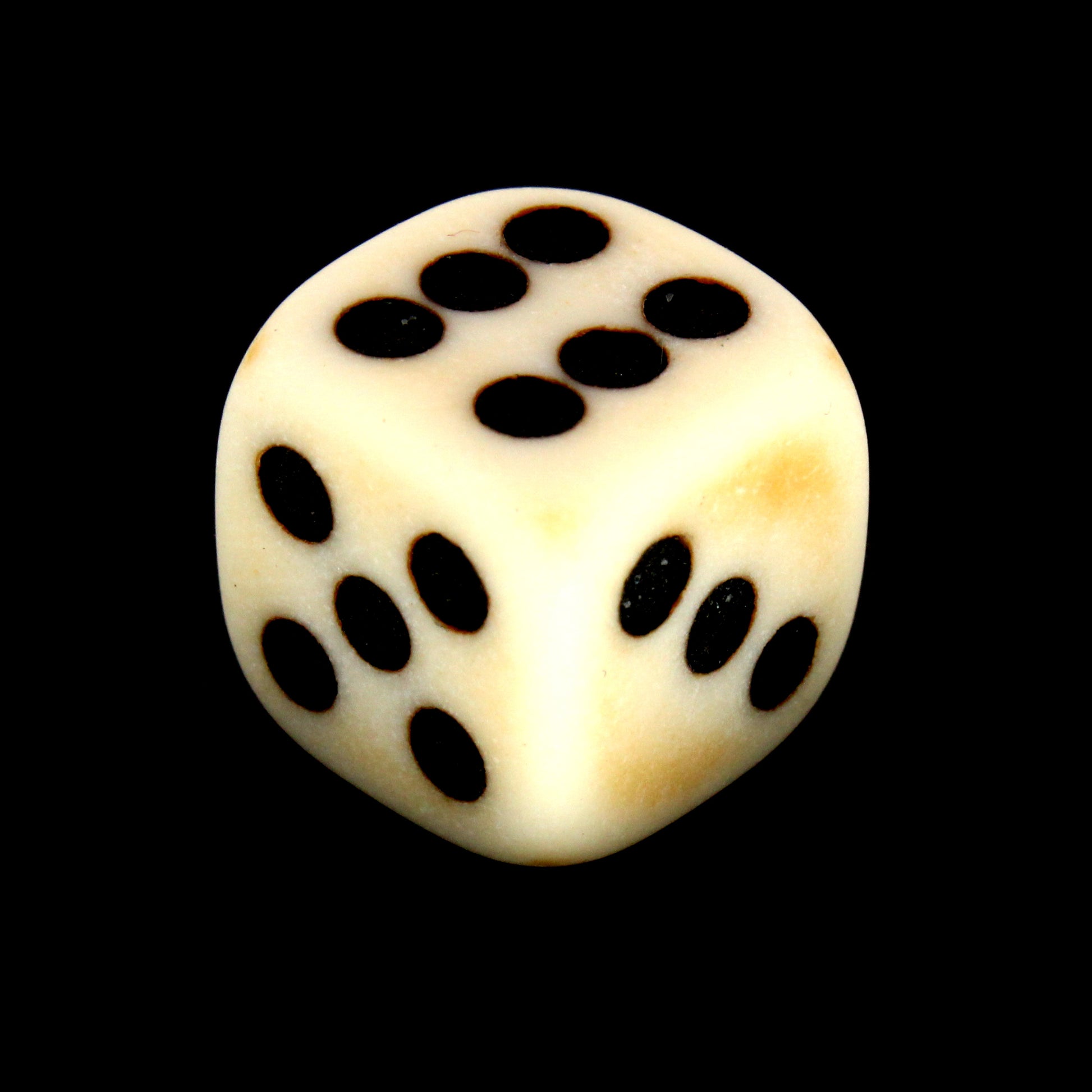 Crag Cat Claw is a 10-piece set of matte pale-colored 12mm d6s, with a natural patina, and pips inked in black.