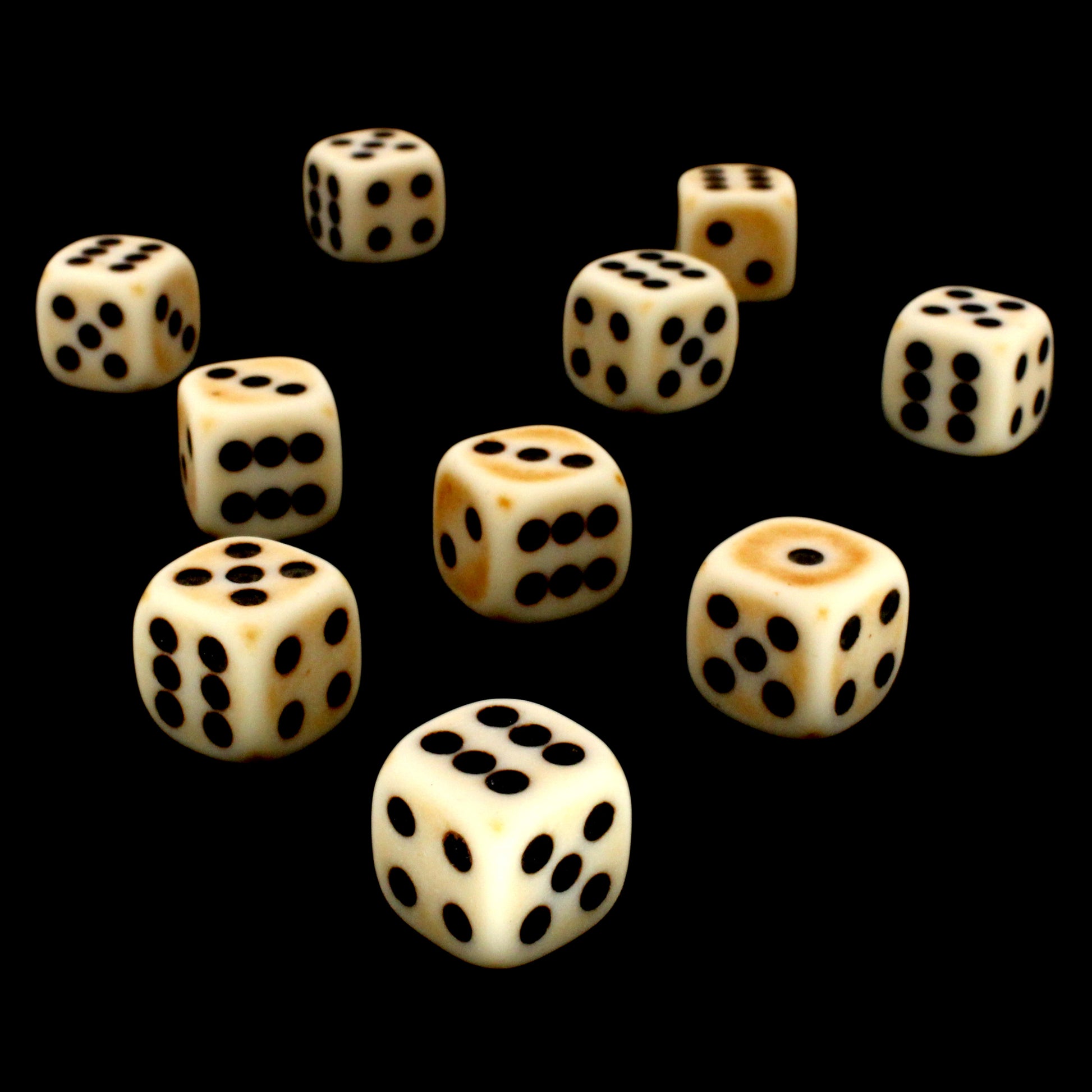 Crag Cat Claw is a 10-piece set of matte pale-colored 12mm d6s, with a natural patina, and pips inked in black.