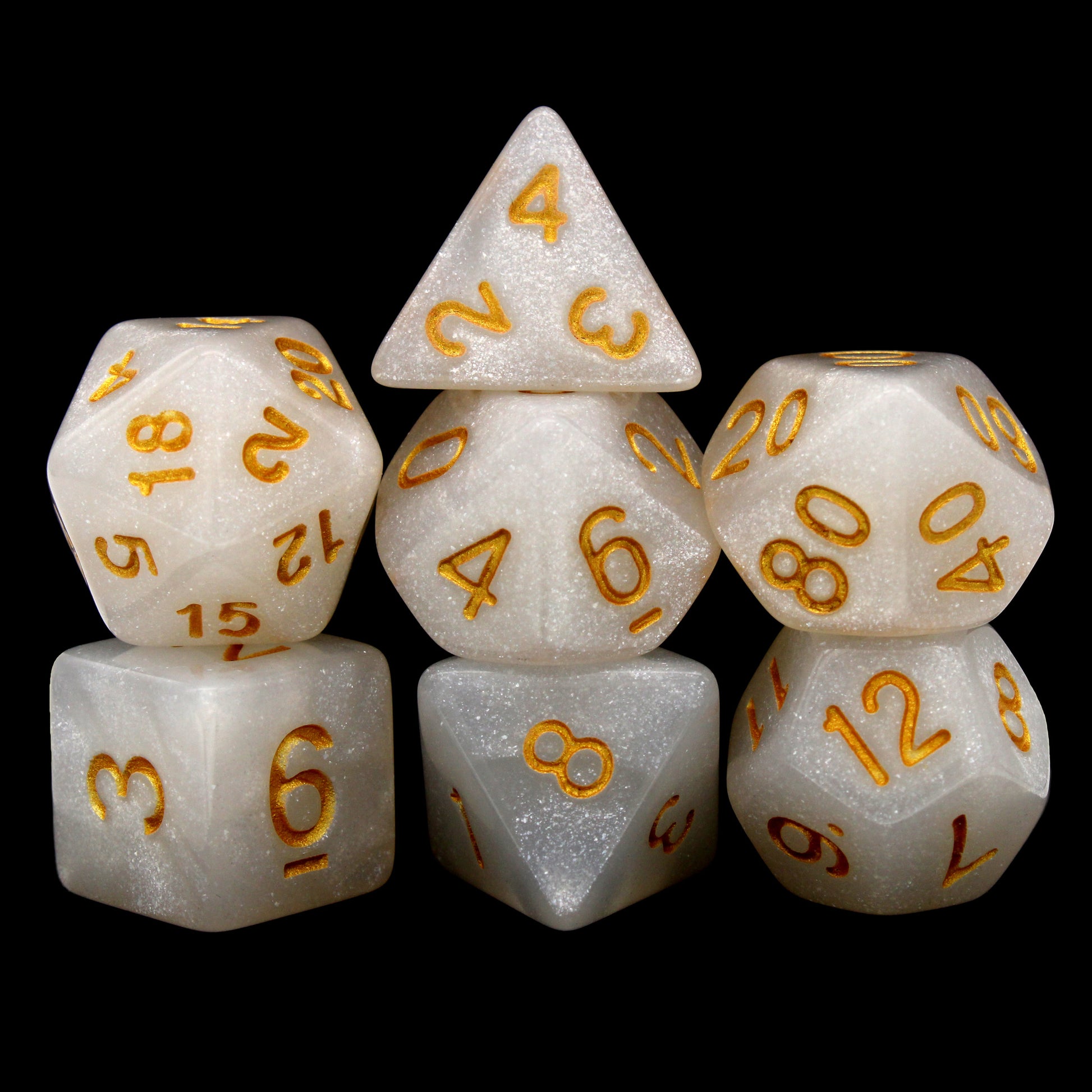Djinni Dust is a 7-piece set of pale white, glittery dice, inked in vibrant gold.