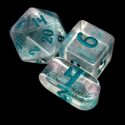 Fifolet is a 10-piece, clear acrylic set with green, iridescent micro-glitter and a rare pearlescent wisp of silvery swirl. The teal ink gives the set an otherworldly aura perfect for any ethereal character at your TTRPG table.