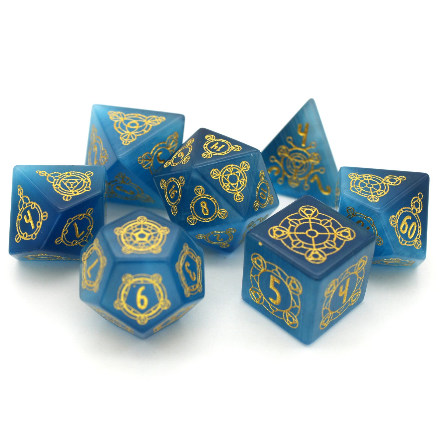 Midsummer's Eve is a 7-piece set of dice cut from blue, lab-made chatoyant stone, engraved with Dice Envy's exclusive Sigil design and inked in gold.