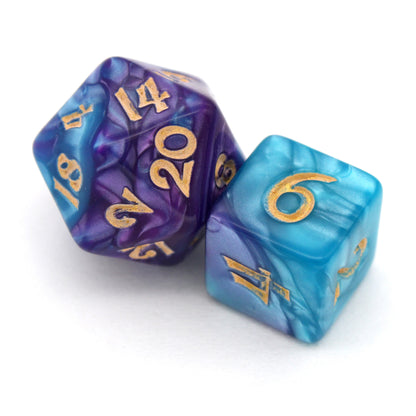Sky Shadow is a 7-piece, 13mm polymer set of swirled blue and purple acrylic dice, inked in gold. It belongs to our tiny but mighty Wee Lads collection. Standard d20 pictured for scale.