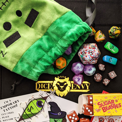 Each Trick or Treat Bag contains a selection of spooky delights, including 3 full sets of dice, as well as an assortment of goodies, all held in a plush Franken-pouch.