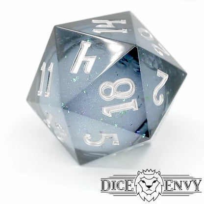 Snow Globe Chonky is a translucent grey-blue, sharp edge resin 33mm d20 with a liquid core of snow white glitter, inked in bright silver.