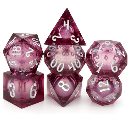 Dionysus's Delight is a 7-piece, translucent magenta, sharp edge resin dice set with a liquid core of color-shifting pearlescent glitter, inked in silver.
