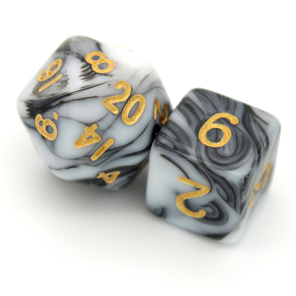 D'lites is a 7-piece 13mm resin dice set with swirls of black and white, inked in pale gold. It belongs to our tiny but mighty Wee Lads collection.