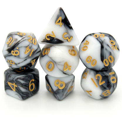 D'lites is a 7-piece 13mm resin dice set with swirls of black and white, inked in pale gold. It belongs to our tiny but mighty Wee Lads collection.