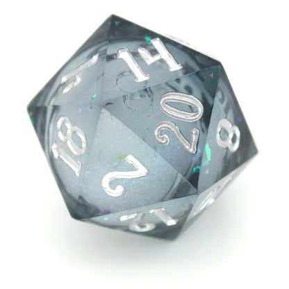 Snow Globe is a 7-piece, translucent grey-blue resin dice set with a liquid core of snow white glitter, inked in bright silver.