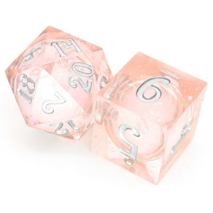 Unicorn Daydreams is a 7-piece, translucent light pink, sharp edge resin dice set with a liquid core of color-shifting pearlescent glitter, inked in silver.