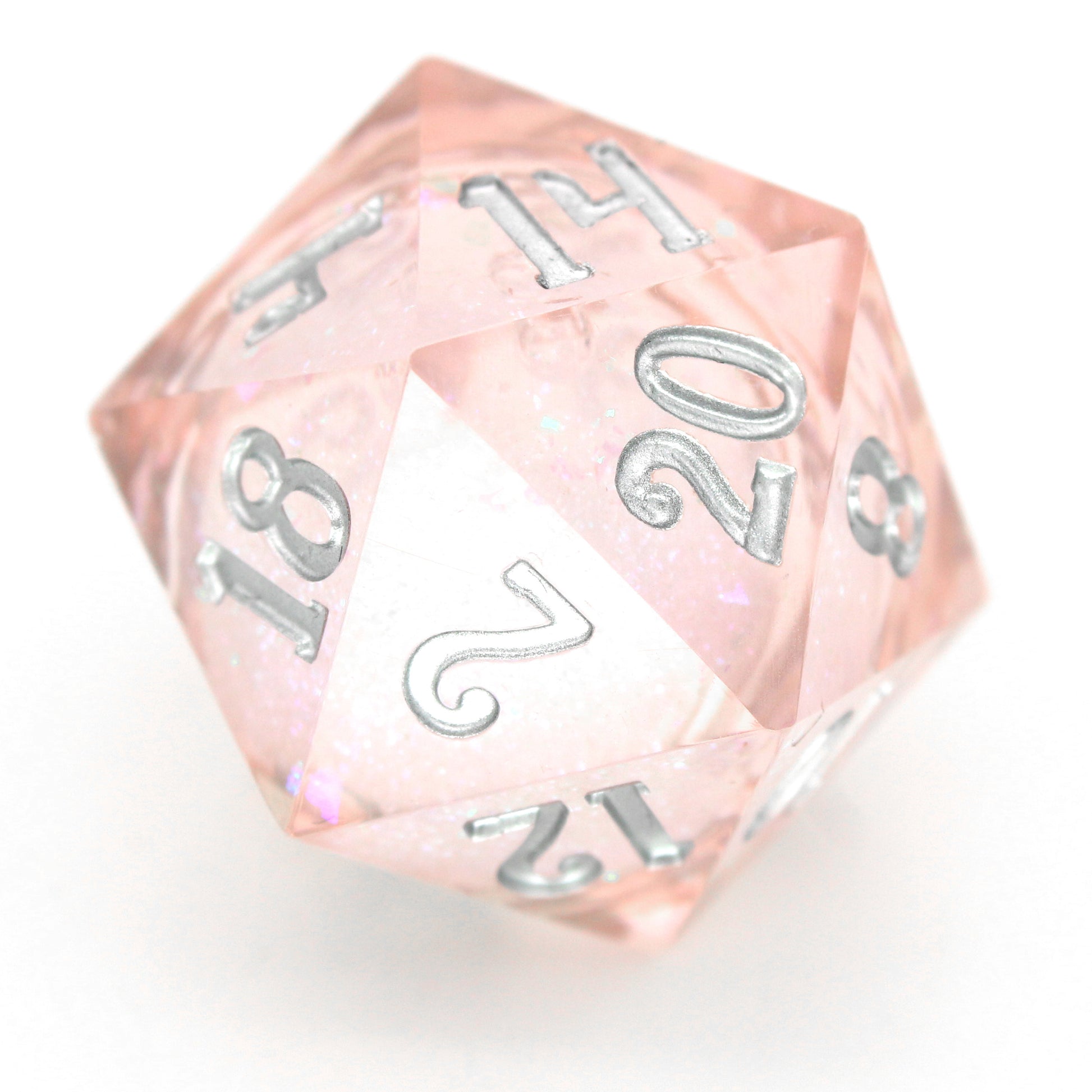 Unicorn Daydreams is a 7-piece, translucent light pink, sharp edge resin dice set with a liquid core of color-shifting pearlescent glitter, inked in silver.